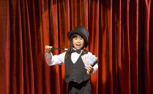 Young girl performing magic trick.