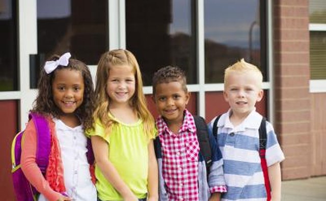 Four elementary children standing in front of school.