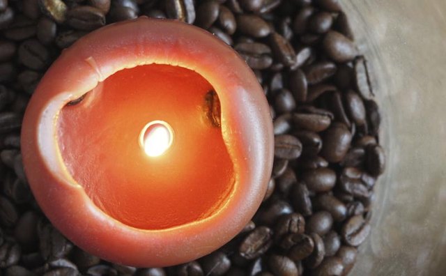 A candle burning in coffee beans.