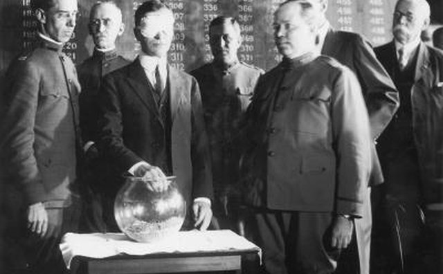 Blindfolded Secretary of War Newton Baker pulls name from glass bowl at the start of World War One