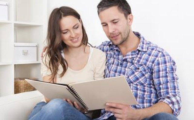 Couple sitting together on couch looking at booklet of questions