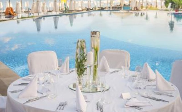 A wedding reception table by the pool at a resort.