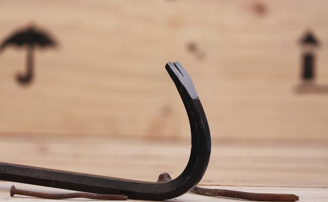 A close-up of a crowbar and a wooden shipping crate.