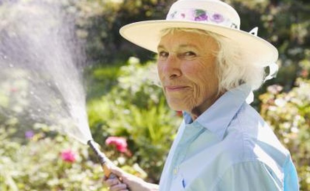 Senior woman watering her garden.