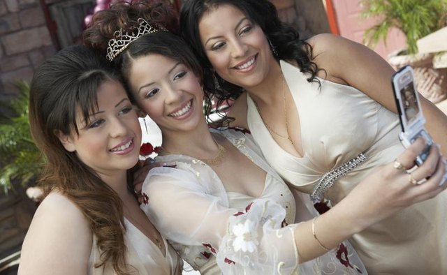 Women taking a selfie while dressed in all white.