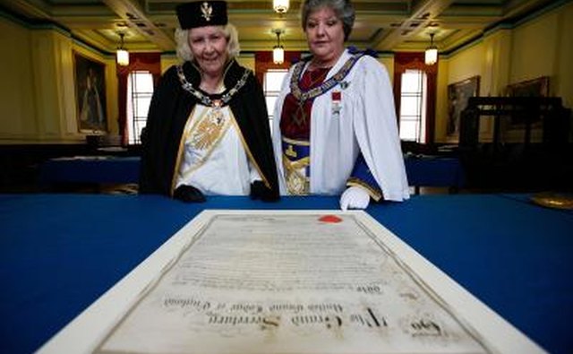 Women freemason leaders look over 1920 petition to the Grand Masonic Temple in London, England to allow women