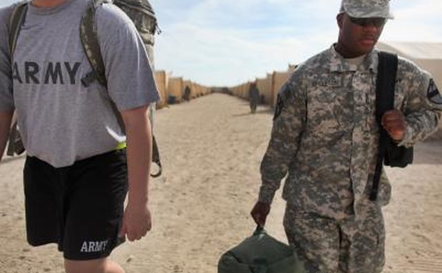 Army sergeant carry gear to staging area
