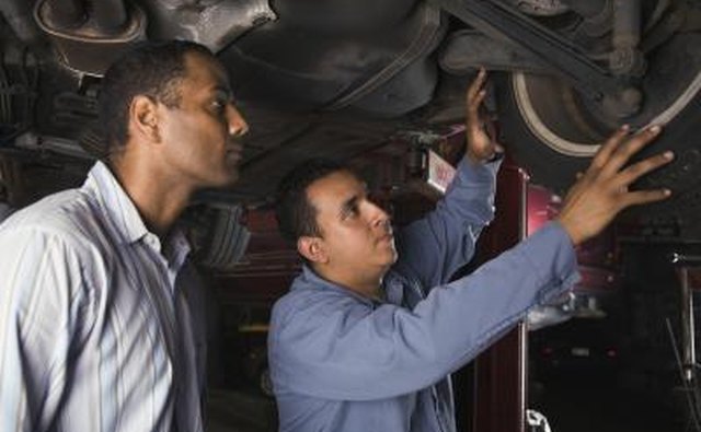 Mechanic and car owner looking at tire