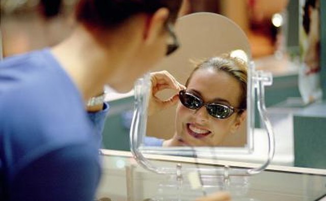 Woman trying on a pair of sunglasses.