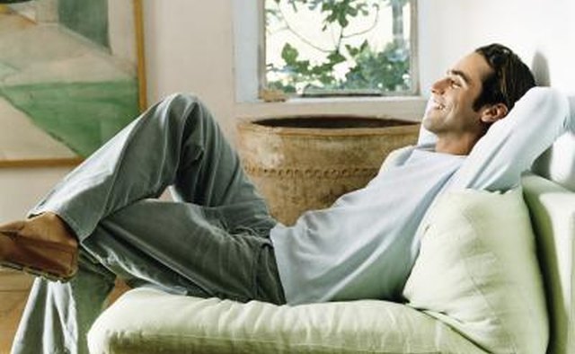 Young man relaxing in armchair, smiling.