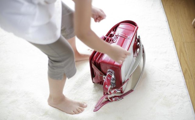 Young girl grabbing her backpack.