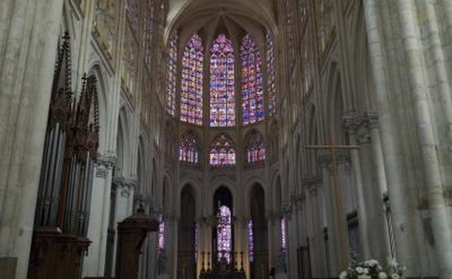 Though Gothic cathedrals allowed for larger windows, stained glass often made the interiors darker, as seen at Saint Gatien.