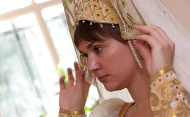 A woman adjusting a kokoshnik.