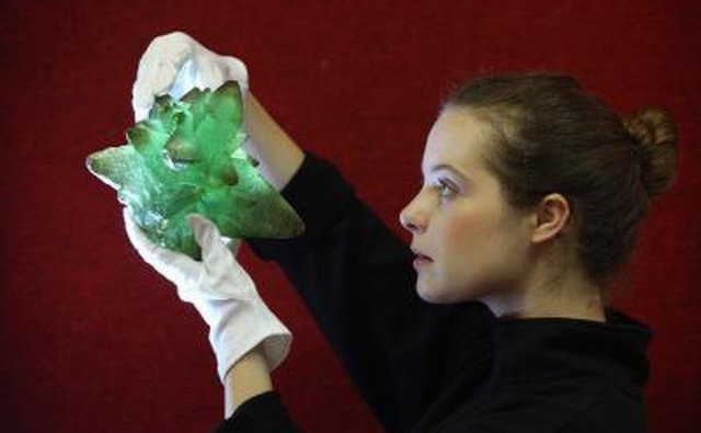 An art handler holds up a piece of kryptonite, a prop used in a Superman film, at an auction.