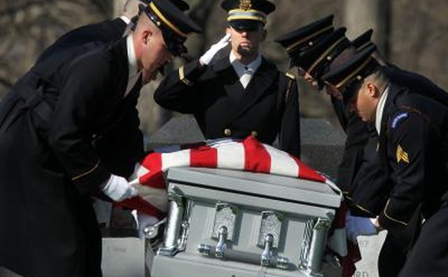 The flag code does require that the flag never touch the ground, so the flag should drape a casket only when it is being viewed.