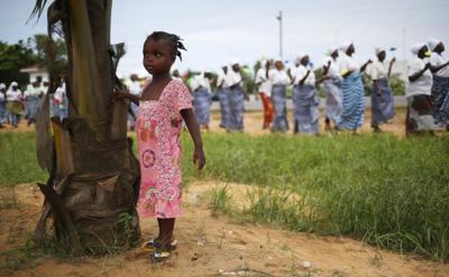 Girl standing next to tree in village