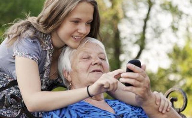Preteen and senior looking at cell phone