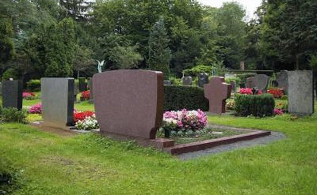 Grave sites on a cemetary lawn.