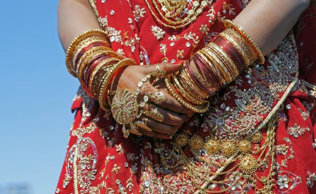 A woman displays bangles on her wrists.