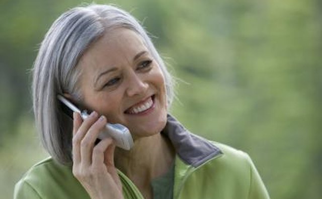 Mature woman talking on phone outdoors.