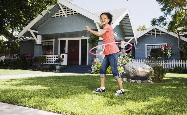 Young girl playing with a hula hoop.
