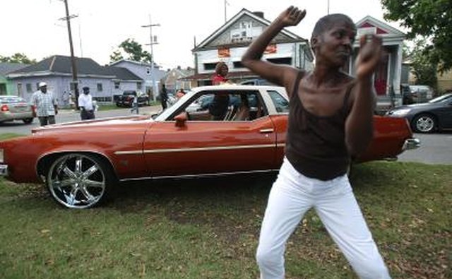 A woman dances to a car stereo on a lawn in New Orleans.