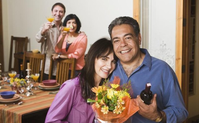Older couple smiling at dinner party.