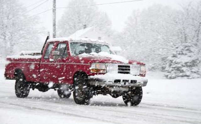 Pick up truck driving in the snow.