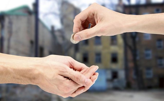 Close-up of coin donation being handed between people