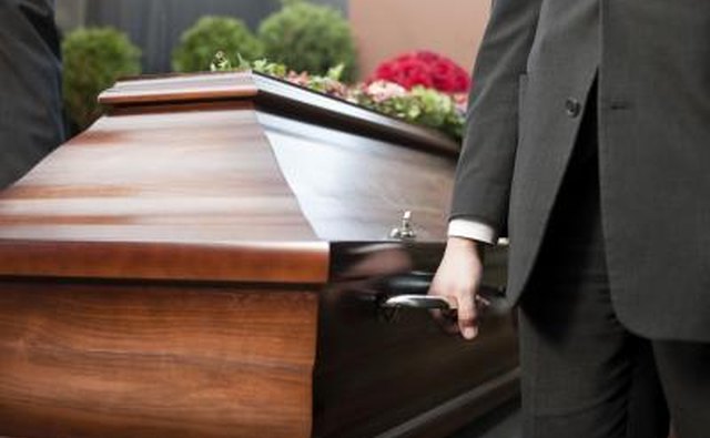 Palm bearers carry a casket.