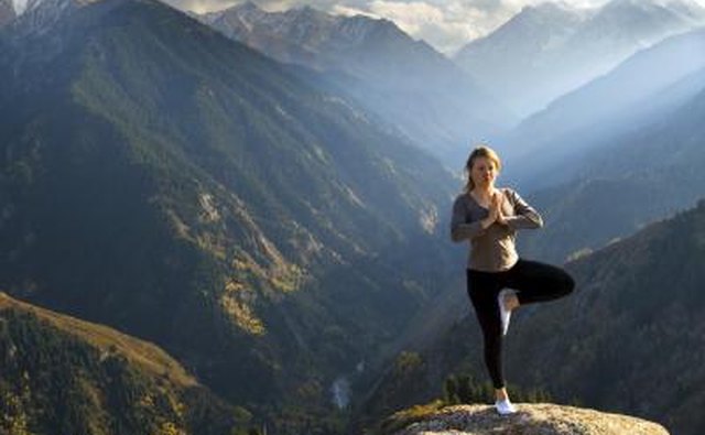 Woman doing yoga on a mountain summit