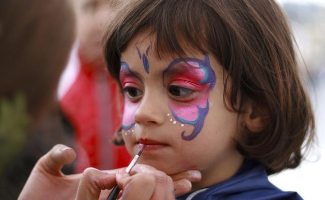 Little girl having her face painted
