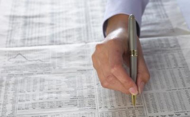 Man looking at stock reports in newspaper