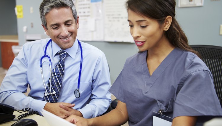 Doctor With Nurse Working At Nurses Station