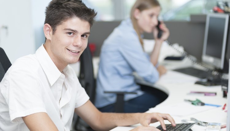 Teenager at computer office first job