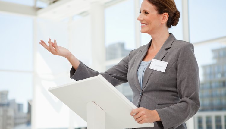 Happy businesswoman speaking at podium