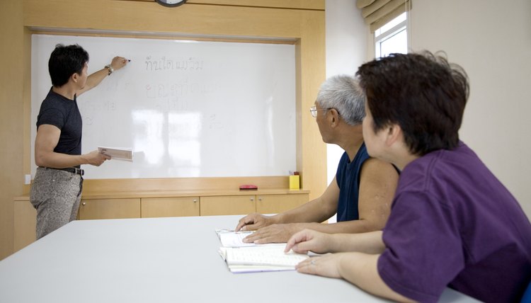 Couple watching man writing on white board