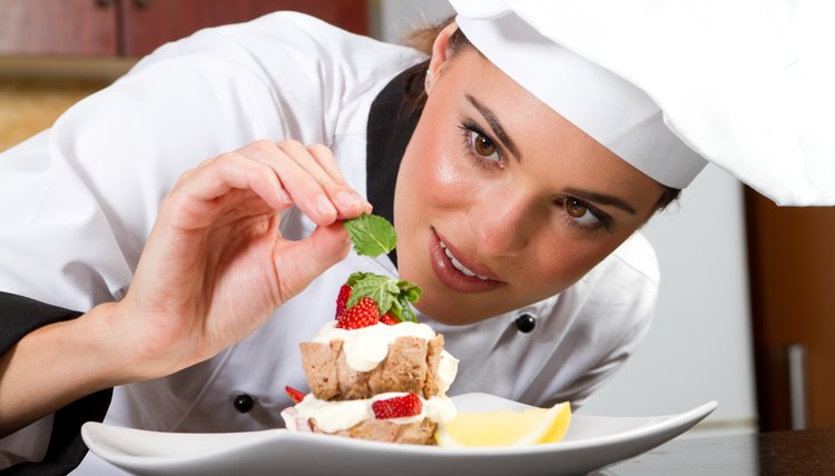 female chef decorating food in kitchen