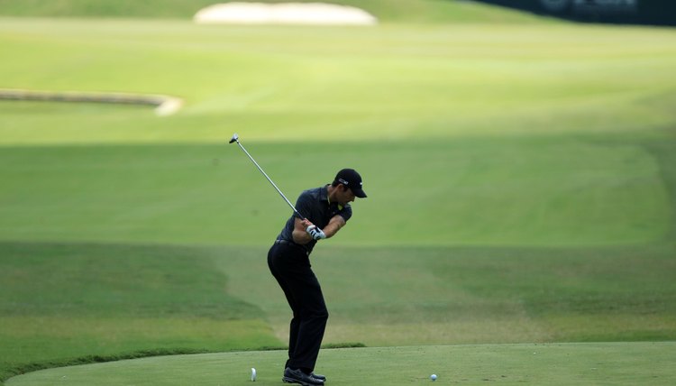 As professional player Charl Schwartzel, the 2011 Masters champion, makes his downswing, his right knee stays bent so he doesn't tilt his spine toward the target.