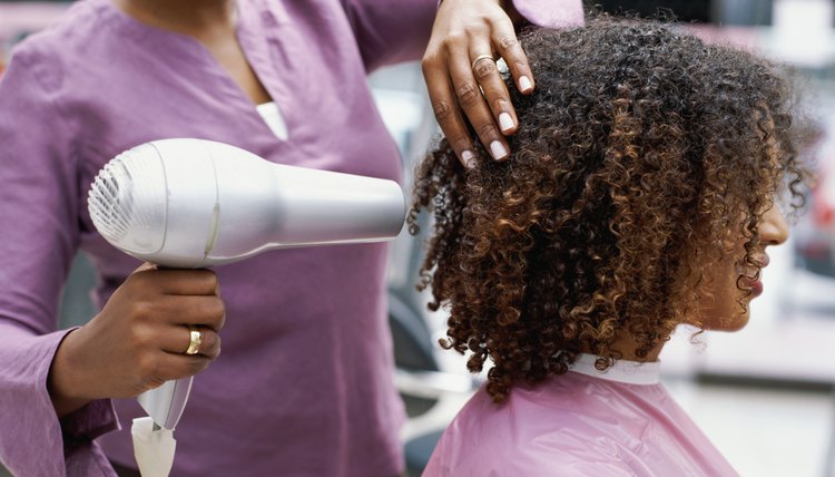 Side profile of a woman having her hair dried with a hair dryer