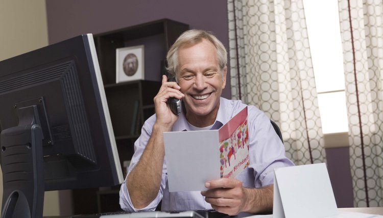 Man on the phone reading a card