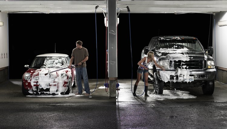 Man and woman washing cars next to each other