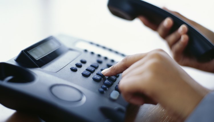 person using a landline phone in an office