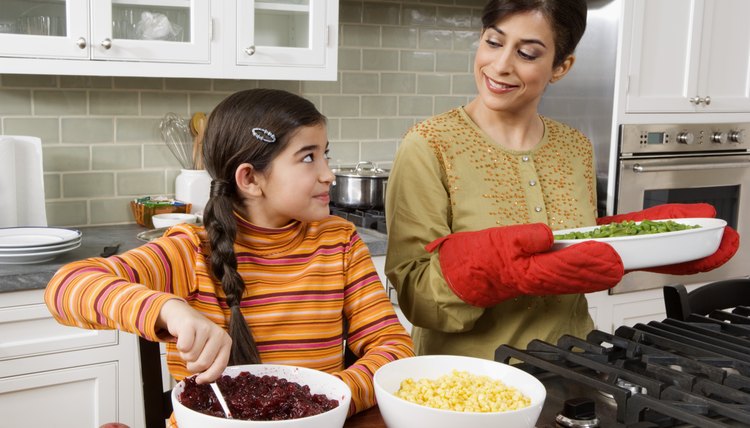 Mother and daughter cooking Thanksgiving meal in kitchen