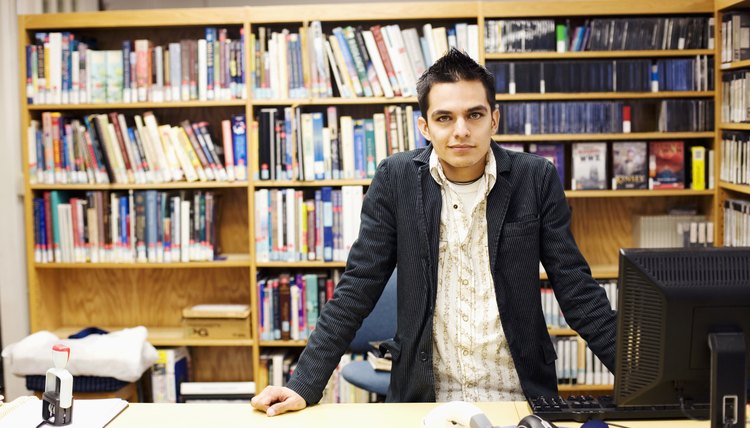 Young man leaning on table in library