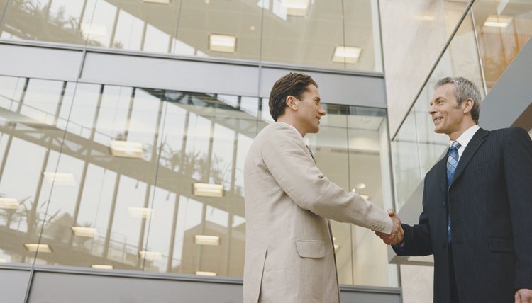 Two Businessmen Shaking Hands Standing Outside an Office Building