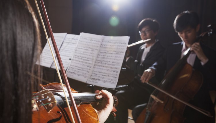 Violinist and other musicians playing during a performance, lens flare
