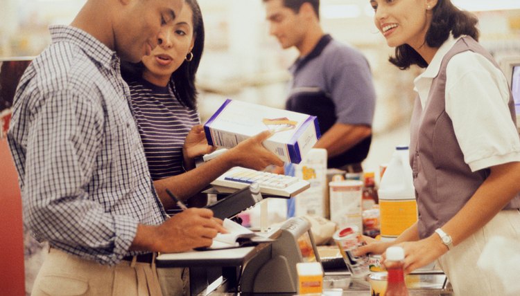 Side profile of a mid adult couple at a checkout counter in a supermarket
