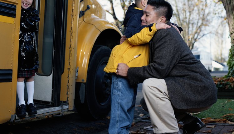 Father Hugging His Son as He Boards a School Bus