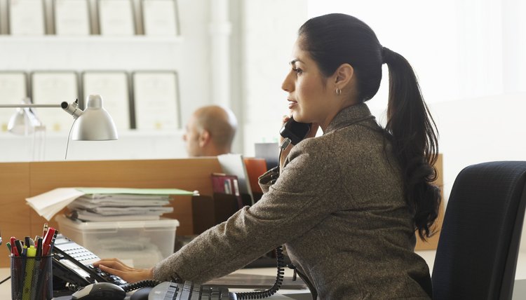 Businesswoman using telephone at desk